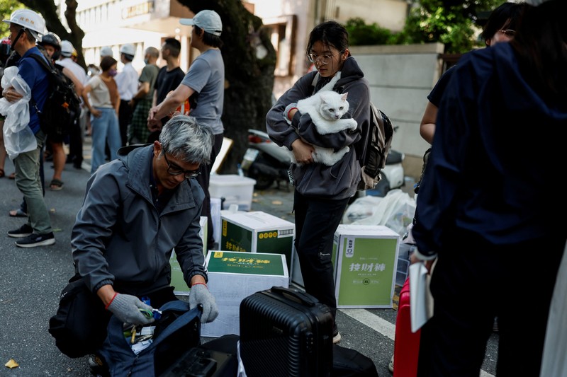 Seorang wanita membawa barang dagangan dari toko sepeda di gedung yang rusak saat orang memindahkan barang dagangan dan barang berharga ke luar gedung, pasca gempa, di Hualien, Taiwan, 4 April 2024. Seorang wanita membawa barang dagangan dari toko sepeda di gedung yang rusak saat orang memindahkan barang dagangan dan barang berharga ke luar gedung, pasca gempa, di Hualien, Taiwan, 4 April 2024. (REUTERS/Carlos Garcia Rawlins)