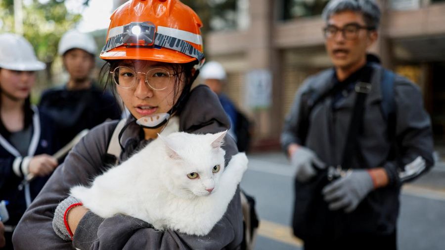 Seorang wanita membawa barang dagangan dari toko sepeda di gedung yang rusak saat orang memindahkan barang dagangan dan barang berharga ke luar gedung, pasca gempa, di Hualien, Taiwan, 4 April 2024. (REUTERS/Carlos Garcia Rawlins)