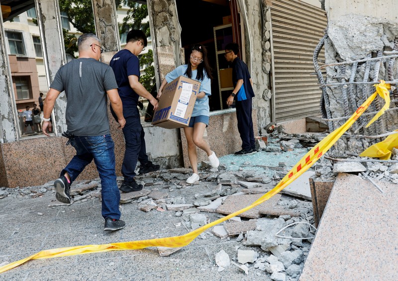 Seorang wanita membawa barang dagangan dari toko sepeda di gedung yang rusak saat orang memindahkan barang dagangan dan barang berharga ke luar gedung, pasca gempa, di Hualien, Taiwan, 4 April 2024. Seorang wanita membawa barang dagangan dari toko sepeda di gedung yang rusak saat orang memindahkan barang dagangan dan barang berharga ke luar gedung, pasca gempa, di Hualien, Taiwan, 4 April 2024. (REUTERS/Carlos Garcia Rawlins)