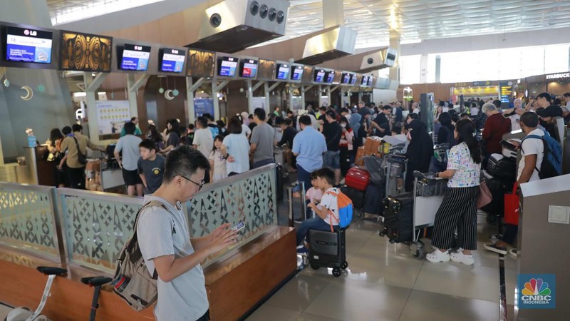 Suasana calon penumpang mengantre di area check in Bandara Soetta, Tangerang, Banten, Sabtu (6/4/2024). (CNBC Indonesia/Muhammad Sabki)