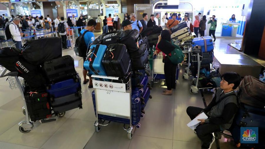 Suasana calon penumpang mengantre di area check in Bandara Soetta, Tangerang, Banten, Sabtu (6/4/2024). (CNBC Indonesia/Muhammad Sabki)