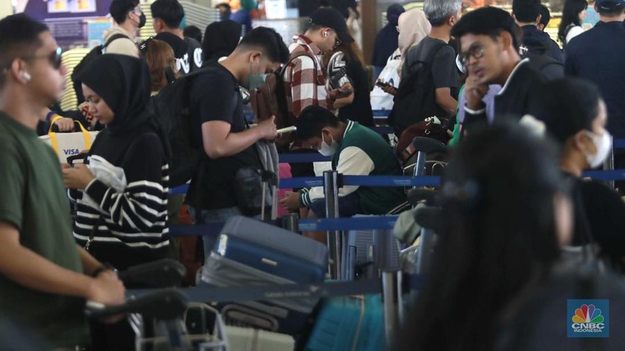 Suasana calon penumpang mengantre di area check in Bandara Soetta, Tangerang, Banten, Sabtu (6/4/2024). (CNBC Indonesia/Muhammad Sabki)