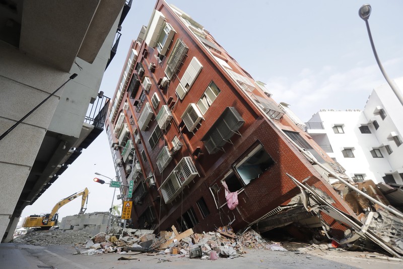 Heavy equipment begins demolition of a collapsed building, two days after a powerful earthquake struck the city, in Hualien City, eastern Taiwan, Friday, April 5, 2024. (AP Photo/Chiang Ying-ying)