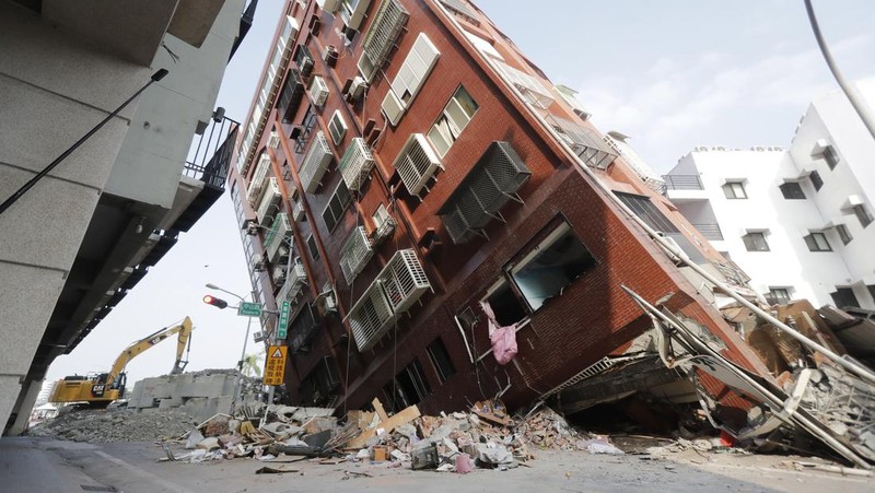 Heavy equipment begins demolition of a collapsed building, two days after a powerful earthquake struck the city, in Hualien City, eastern Taiwan, Friday, April 5, 2024. (AP Photo/Chiang Ying-ying)