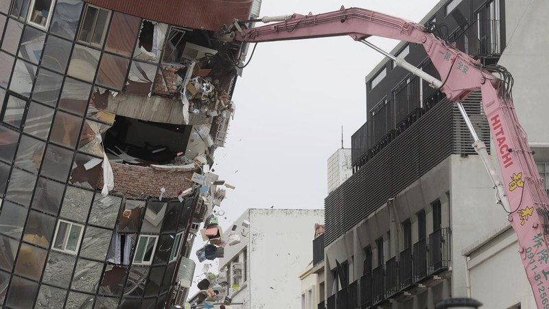 Heavy equipment begins demolition of a collapsed building, two days after a powerful earthquake struck the city, in Hualien City, eastern Taiwan, Friday, April 5, 2024. (AP Photo/Chiang Ying-ying)