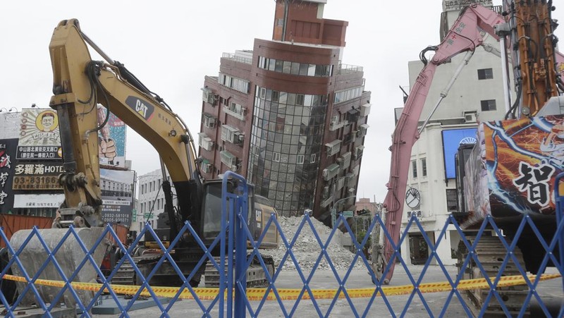Heavy equipment begins demolition of a collapsed building, two days after a powerful earthquake struck the city, in Hualien City, eastern Taiwan, Friday, April 5, 2024. (AP Photo/Chiang Ying-ying)