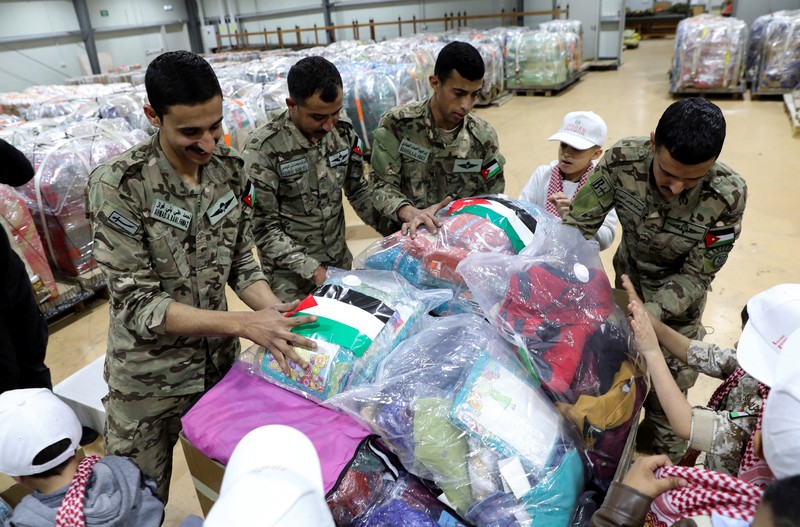 Anak-anak membantu personel militer mengemas bantuan pakaian yang akan diturunkan dari udara di Gaza, menjelang perayaan Idul Fitri, di Zarqa, Yordania. (REUTERS/Alaa Al Sukhni) Anak-anak membantu personel militer mengemas bantuan pakaian yang akan diturunkan dari udara di Gaza, menjelang perayaan Idul Fitri, di Zarqa, Yordania. (REUTERS/Alaa Al Sukhni)
