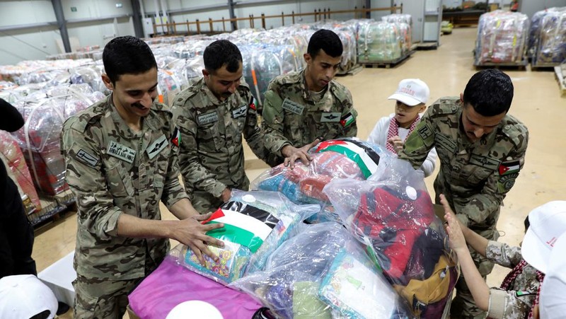 Anak-anak membantu personel militer mengemas bantuan pakaian yang akan diturunkan dari udara di Gaza, menjelang perayaan Idul Fitri, di Zarqa, Yordania. (REUTERS/Alaa Al Sukhni)