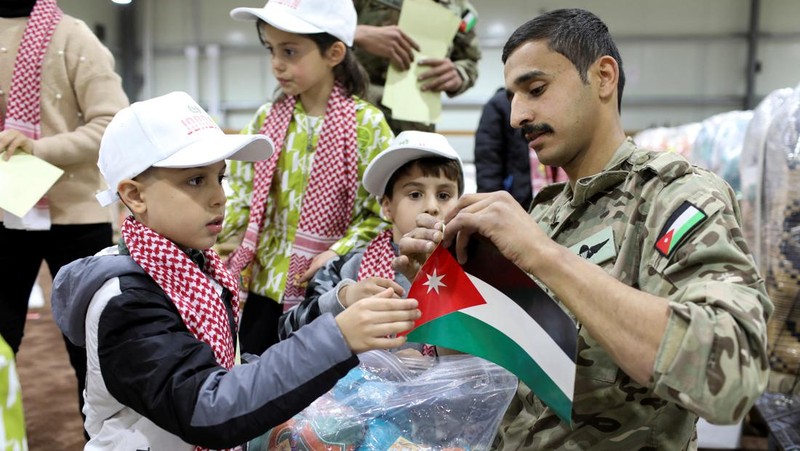 Anak-anak membantu personel militer mengemas bantuan pakaian yang akan diturunkan dari udara di Gaza, menjelang perayaan Idul Fitri, di Zarqa, Yordania. (REUTERS/Alaa Al Sukhni)
