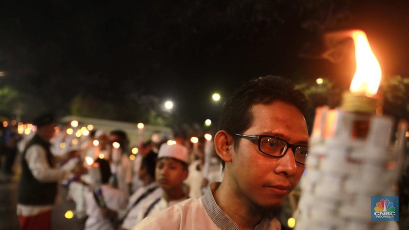 Sekelompok warga melakukak pawai obor malam takbiran untuk menyambut Hari Raya Idul Fitri 1445 Hijriah di kawasan Masjid Istiqlal, Jakarta, Selasa, (9/4/2024). (CNBC Idonesia/Muhammad Sabki)