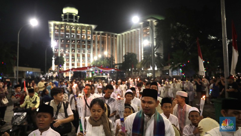 Sekelompok warga melakukak pawai obor malam takbiran untuk menyambut Hari Raya Idul Fitri 1445 Hijriah di kawasan Masjid Istiqlal, Jakarta, Selasa, (9/4/2024). (CNBC Idonesia/Muhammad Sabki)