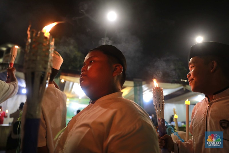 Sekelompok warga melakukak pawai obor malam takbiran untuk menyambut Hari Raya Idul Fitri 1445 Hijriah di kawasan Masjid Istiqlal, Jakarta, Selasa, (9/4/2024). (CNBC Idonesia/Muhammad Sabki)