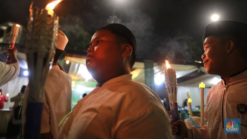 Sekelompok warga melakukak pawai obor malam takbiran untuk menyambut Hari Raya Idul Fitri 1445 Hijriah di kawasan Masjid Istiqlal, Jakarta, Selasa, (9/4/2024). (CNBC Idonesia/Muhammad Sabki)