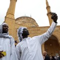 Jemaah Muslim dari Sudan berfoto selfie sambil mengenakan keffiyeh saat salat Idul Fitri, menandai akhir bulan suci Ramadhan, di luar masjid Al-Amin di pusat kota Beirut, Lebanon 10 April 2024. (REUTERS/Mohamed Azakir)