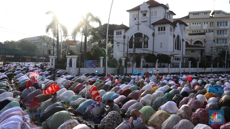 Umat muslim melaksanakan ibadah solat salat Idul Fitri 1445 H di jalan tepat di sebelah kanan dan kiri Gereja Koinonia Jakarta, Jakarta Timur, Sabtu (22/4/2023). (CNBC Indonesia/Muhammad Sabki)