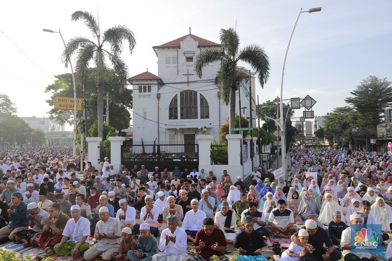 Umat muslim melaksanakan ibadah solat salat Idul Fitri 1445 H di jalan tepat di sebelah kanan dan kiri Gereja Koinonia Jakarta, Jakarta Timur, Sabtu (22/4/2023). (CNBC Indonesia/Muhammad Sabki)