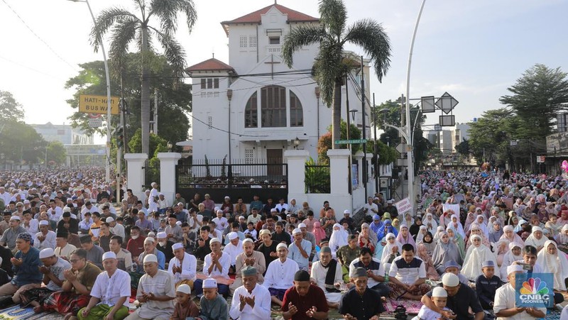 Umat muslim melaksanakan ibadah solat salat Idul Fitri 1445 H di jalan tepat di sebelah kanan dan kiri Gereja Koinonia Jakarta, Jakarta Timur, Sabtu (22/4/2023). (CNBC Indonesia/Muhammad Sabki)