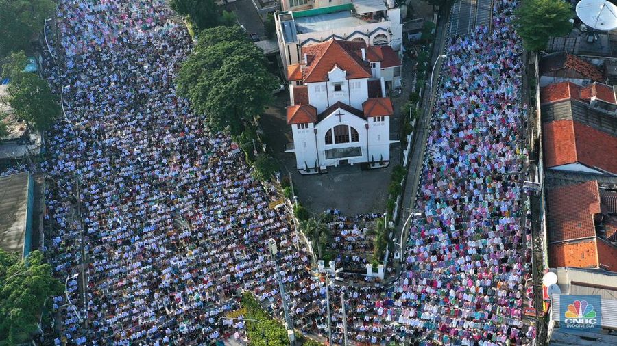 Umat muslim melaksanakan ibadah solat salat Idul Fitri 1445 H di jalan tepat di sebelah kanan dan kiri Gereja Koinonia Jakarta, Jakarta Timur, Sabtu (22/4/2023). (CNBC Indonesia/Muhammad Sabki)