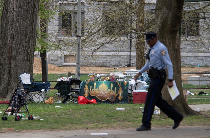 Seorang petugas polisi berpatroli di area penembakan yang terjadi saat acara Idul Fitri di Clara Muhammad Square di West Philadelphia, Pennsylvania, AS, 10 April 2024. (REUTERS/Matthew Hatcher)