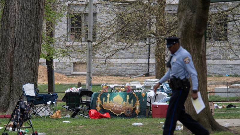 Seorang petugas polisi berpatroli di area penembakan yang terjadi saat acara Idul Fitri di Clara Muhammad Square di West Philadelphia, Pennsylvania, AS, 10 April 2024. (REUTERS/Matthew Hatcher)