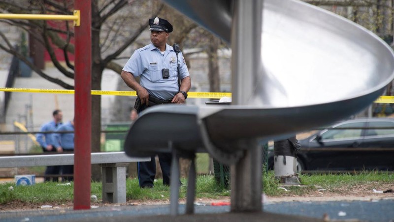 Seorang petugas polisi berpatroli di area penembakan yang terjadi saat acara Idul Fitri di Clara Muhammad Square di West Philadelphia, Pennsylvania, AS, 10 April 2024. (REUTERS/Matthew Hatcher)