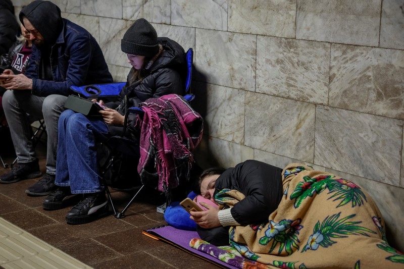 Warga berlindung di dalam stasiun metro bersama putrinya Varvara selama serangan rudal Rusia, di tengah serangan Rusia ke Ukraina, di Kyiv, Ukraina, Kamis (11/4/2024). (REUTERS/Alina Smutko)