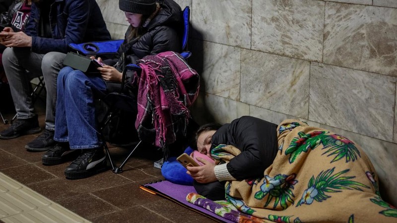 Warga berlindung di dalam stasiun metro bersama putrinya Varvara selama serangan rudal Rusia, di tengah serangan Rusia ke Ukraina, di Kyiv, Ukraina, Kamis (11/4/2024). (REUTERS/Alina Smutko)