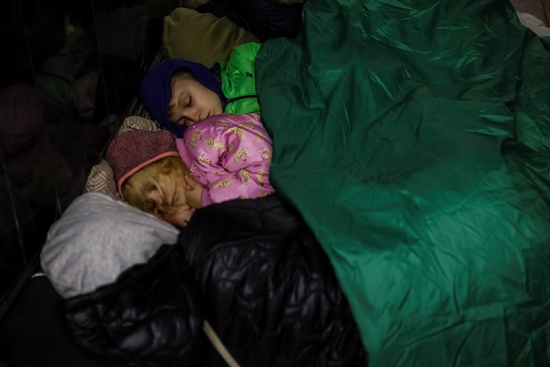 Warga berlindung di dalam stasiun metro bersama putrinya Varvara selama serangan rudal Rusia, di tengah serangan Rusia ke Ukraina, di Kyiv, Ukraina, Kamis (11/4/2024). (REUTERS/Alina Smutko)