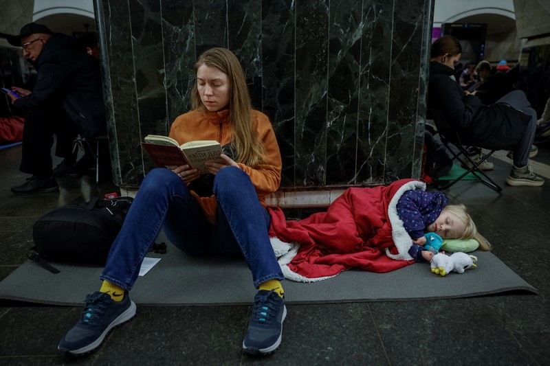 Warga berlindung di dalam stasiun metro bersama putrinya Varvara selama serangan rudal Rusia, di tengah serangan Rusia ke Ukraina, di Kyiv, Ukraina, Kamis (11/4/2024). (REUTERS/Alina Smutko)