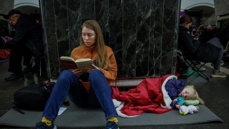 Warga berlindung di dalam stasiun metro bersama putrinya Varvara selama serangan rudal Rusia, di tengah serangan Rusia ke Ukraina, di Kyiv, Ukraina, Kamis (11/4/2024). (REUTERS/Alina Smutko)