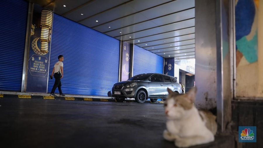 Pengendara sepeda motor melintas di depan Blok A Pasar Tanah Abang yang tutup di Jakarta, Jumat (12/4/2024). (CNBC Indonesia/Faisal Rahman)