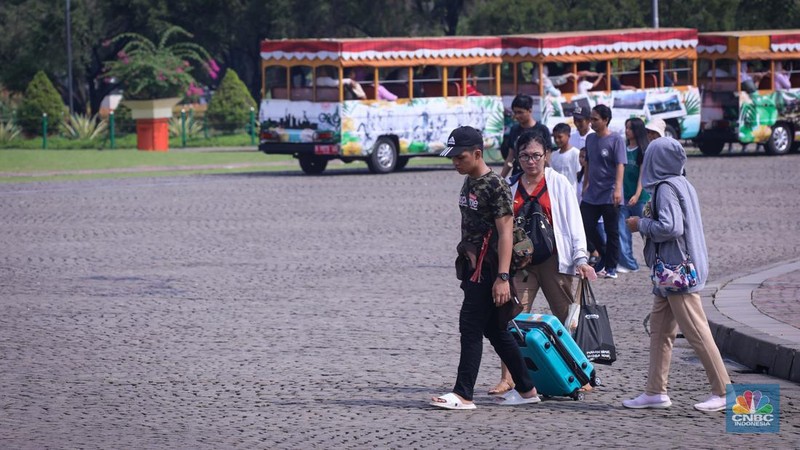 Sejumlah pengunjung berwisata di Kawasan Monumen Nasional (Monas), Jakarta, Jumat (12/4/2024). (CNBC Indonesia/Faisal Rahman)