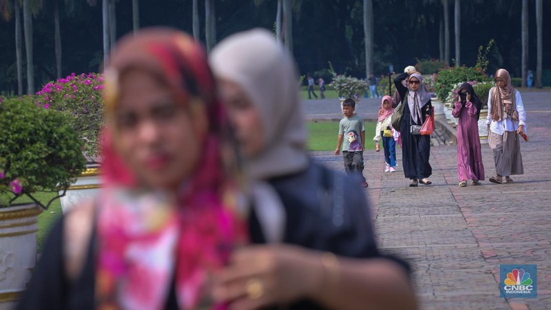 Sejumlah pengunjung berwisata di Kawasan Monumen Nasional (Monas), Jakarta, Jumat (12/4/2024). (CNBC Indonesia/Faisal Rahman)