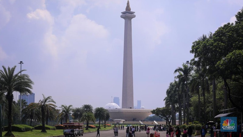Sejumlah pengunjung berwisata di Kawasan Monumen Nasional (Monas), Jakarta, Jumat (12/4/2024). (CNBC Indonesia/Faisal Rahman)