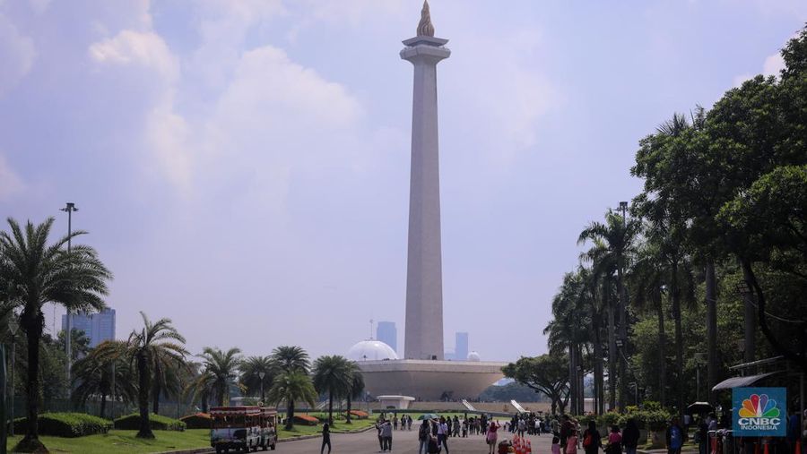 Sejumlah pengunjung berwisata di Kawasan Monumen Nasional (Monas), Jakarta, Jumat (12/4/2024). (CNBC Indonesia/Faisal Rahman)