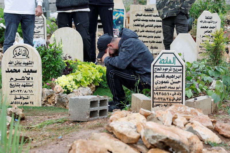 Warga Palestina mengunjungi makam kerabat mereka yang dibunuh oleh Israel, pada hari pertama Idul Fitri, yang menandai berakhirnya bulan puasa Ramadhan, di kamp Jenin di Tepi Barat yang diduduki Israel, 10 April. 2024. Warga Palestina mengunjungi makam kerabat mereka yang dibunuh oleh Israel, pada hari pertama Idul Fitri, yang menandai berakhirnya bulan puasa Ramadhan, di kamp Jenin di Tepi Barat yang diduduki Israel, 10 April. 2024. (REUTERS/Raneen Sawafta)