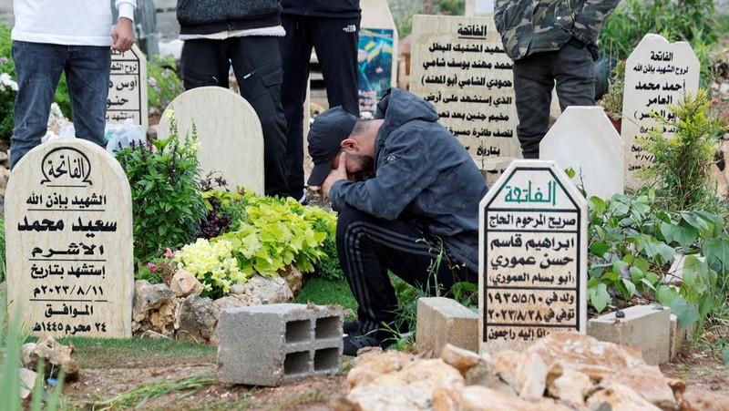 Warga Palestina mengunjungi makam kerabat mereka yang dibunuh oleh Israel, pada hari pertama Idul Fitri, yang menandai berakhirnya bulan puasa Ramadhan, di kamp Jenin di Tepi Barat yang diduduki Israel, 10 April. 2024. (REUTERS/Raneen Sawafta)