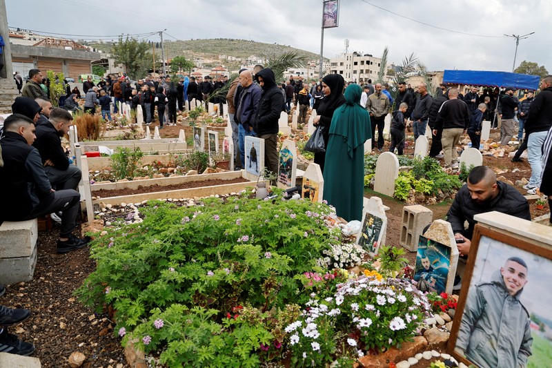Warga Palestina mengunjungi makam kerabat mereka yang dibunuh oleh Israel, pada hari pertama Idul Fitri, yang menandai berakhirnya bulan puasa Ramadhan, di kamp Jenin di Tepi Barat yang diduduki Israel, 10 April. 2024. (REUTERS/Raneen Sawafta)