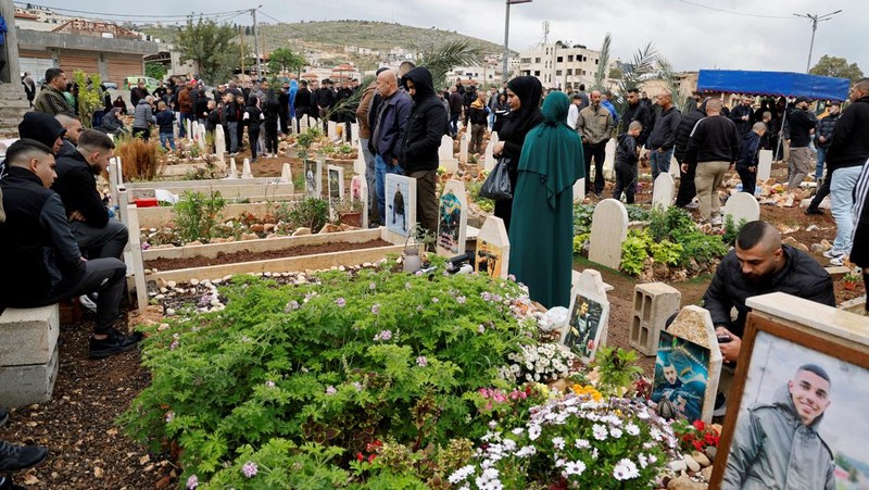 Warga Palestina mengunjungi makam kerabat mereka yang dibunuh oleh Israel, pada hari pertama Idul Fitri, yang menandai berakhirnya bulan puasa Ramadhan, di kamp Jenin di Tepi Barat yang diduduki Israel, 10 April. 2024. (REUTERS/Raneen Sawafta)