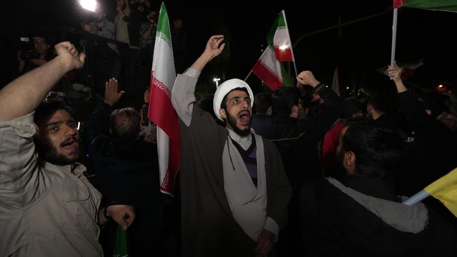 Demonstran Iran meneriakkan slogan-slogan saat berkumpul anti-Israel di depan Kedutaan Besar Inggris di Teheran, Iran, Minggu pagi, 14 April 2024. Iran melancarkan serangan militer langsung pertamanya terhadap Israel pada Sabtu. (AP Photo/Vahid Salemi)