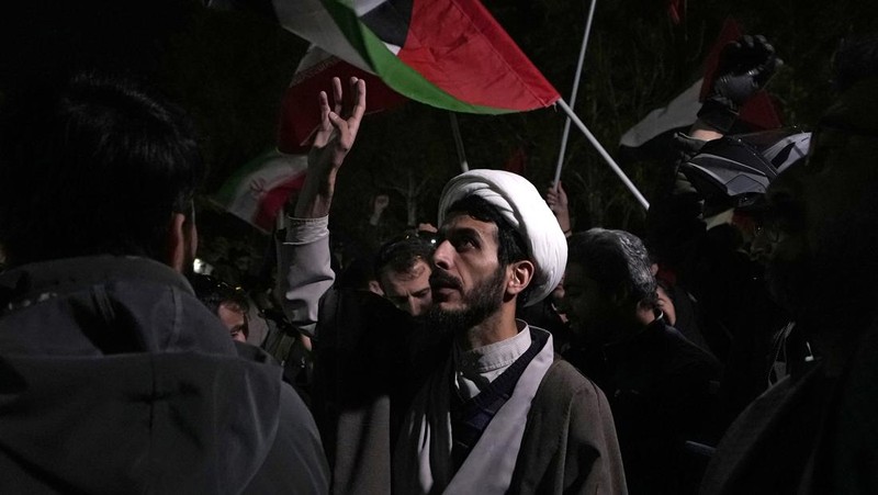 Demonstran Iran meneriakkan slogan-slogan saat berkumpul anti-Israel di depan Kedutaan Besar Inggris di Teheran, Iran, Minggu pagi, 14 April 2024. Iran melancarkan serangan militer langsung pertamanya terhadap Israel pada Sabtu. (AP Photo/Vahid Salemi)