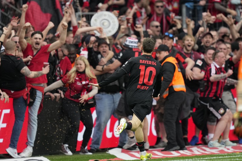 Pendukung Leverkusen merayakannya setelah Bayer Leverkusen meraih gelar Bundesliga Jerman dengan mengalahkan Werder Bremen di Leverkusen, Jerman, Minggu, 14 April 2024. (AP Photo/Martin Meissner)