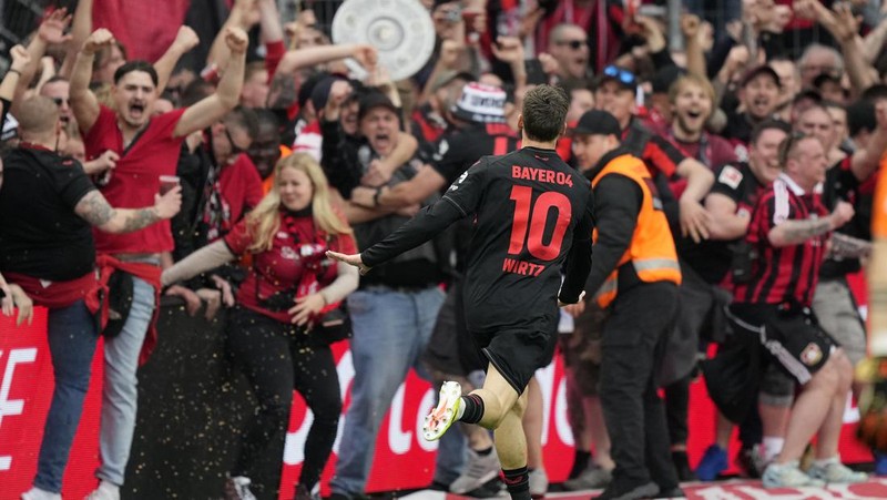 Pendukung Leverkusen merayakannya setelah Bayer Leverkusen meraih gelar Bundesliga Jerman dengan mengalahkan Werder Bremen di Leverkusen, Jerman, Minggu, 14 April 2024. (AP Photo/Martin Meissner)