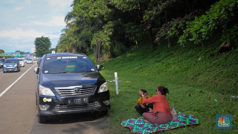 Pemudik beristirahat saat arus balik di bahu jalan ruas tol Jakarta-Cikampek (Japek), Jawa Barat, Senin (15/4/2024). (CNBC Indonesia/Faisal Rahman)
