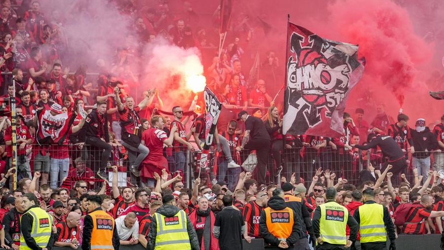 Pendukung Leverkusen merayakannya setelah Bayer Leverkusen meraih gelar Bundesliga Jerman dengan mengalahkan Werder Bremen di Leverkusen, Jerman, Minggu, 14 April 2024. (AP Photo/Martin Meissner)