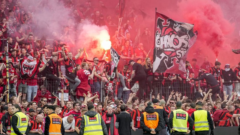 Pendukung Leverkusen merayakannya setelah Bayer Leverkusen meraih gelar Bundesliga Jerman dengan mengalahkan Werder Bremen di Leverkusen, Jerman, Minggu, 14 April 2024. (AP Photo/Martin Meissner)