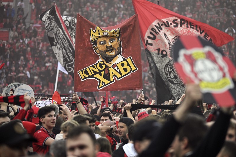 Pendukung Leverkusen merayakannya setelah Bayer Leverkusen meraih gelar Bundesliga Jerman dengan mengalahkan Werder Bremen di Leverkusen, Jerman, Minggu, 14 April 2024. (AP Photo/Martin Meissner)