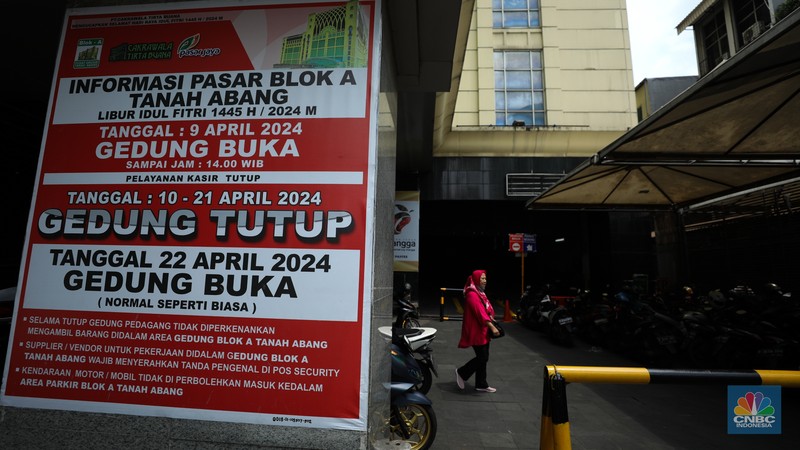 Warga melintas di depan Pasar Tanah Abang Blok A yang tutup di Jakarta, Selasa (16/4/2024). (CNBC Indonesia/Tri Susilo)