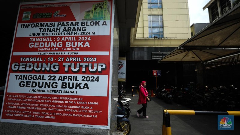 Warga melintas di depan Pasar Tanah Abang Blok A yang tutup di Jakarta, Selasa (16/4/2024). (CNBC Indonesia/Tri Susilo)