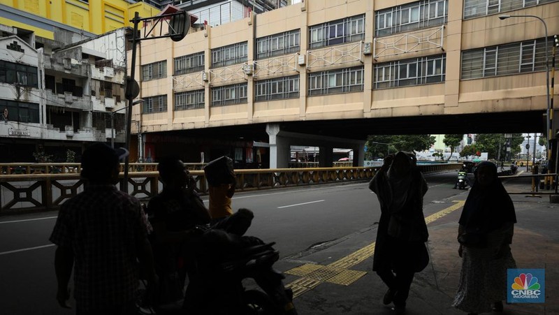 Warga melintas di depan Pasar Tanah Abang Blok A yang tutup di Jakarta, Selasa (16/4/2024). (CNBC Indonesia/Tri Susilo)